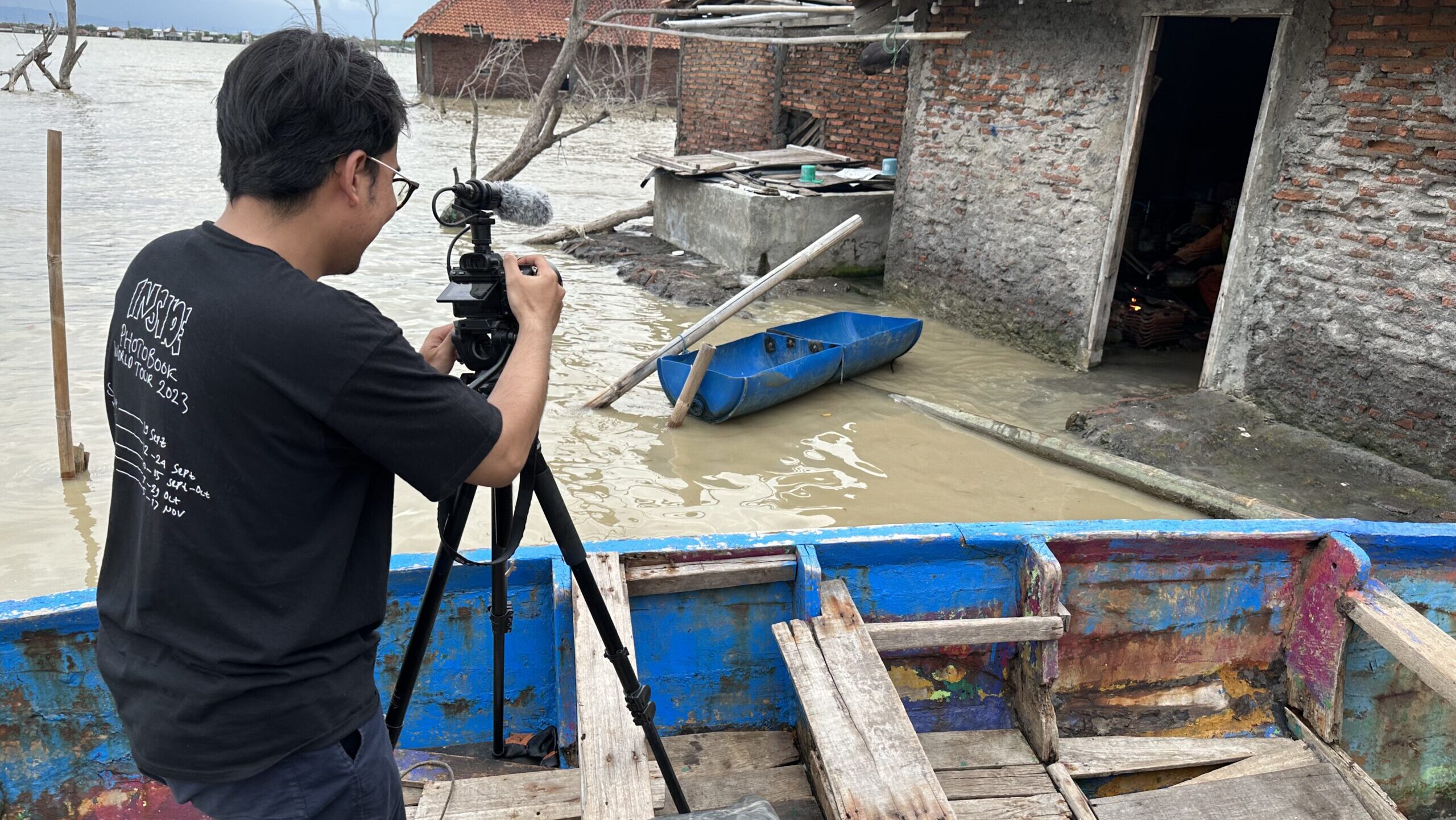 Ivendiyan sedang merekam keadaan rumah yang terkena rob di Demak, Jawa Tengah